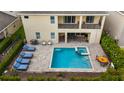 Aerial view of the backyard featuring a private pool, spa, lounge chairs, and outdoor dining area at 7616 Brookhurst Ln, Kissimmee, FL 34747