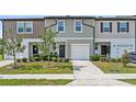 Inviting townhome showcasing a well-maintained lawn, charming shrubbery, and a private garage at 955 Grandin St, Davenport, FL 33837