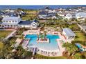 Aerial view of community pool with sun loungers, cabana, palm trees, and ocean views in the background at 960 Civitas Way, Winter Garden, FL 34787