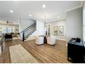 Bright living room with hardwood floors, a round table and chairs, and a staircase to the second level at 960 Civitas Way, Winter Garden, FL 34787