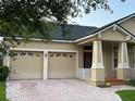 Charming home with a well-manicured lawn, mature trees, and a brick paver driveway leading to a 2-car garage at 9721 Old Patina Way, Orlando, FL 32832