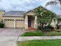 Single-story home features a two-car garage, lush front yard, and a well-manicured lawn at 9721 Old Patina Way, Orlando, FL 32832
