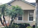 Lovely front porch featuring neutral paint, trim, white railings, and mature palm trees at 9721 Old Patina Way, Orlando, FL 32832