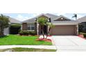 Charming one-story home featuring tidy landscaping, beautiful lawn, and neutral tones at 9824 Secret Cove Ln, Orlando, FL 32832