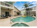 Inviting pool area featuring a spa, covered seating, and a second-story balcony with comfortable seating at 114 Harwood Cir, Kissimmee, FL 34744