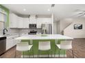 Bright, spacious kitchen with white cabinetry, stainless appliances, and modern island with seating at 11844 Founders St, Orlando, FL 32832