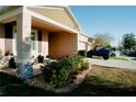 Beige single-story home featuring a front porch, stone accents, well manicured lawn and landscaping at 153 Taft Dr, Davenport, FL 33837