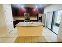 Well-appointed kitchen featuring stainless steel appliances, an island sink, and dark wood cabinets at 2242 Seven Oaks Dr, St Cloud, FL 34772
