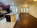 Spacious living room and kitchen with stainless appliances, ample counter space, and hardwood floors at 2242 Seven Oaks Dr, St Cloud, FL 34772