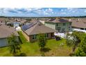 Backyard view of single Gathering home featuring solar panels, grill and back patio at 2726 Harmonia Hammock Rd, Harmony, FL 34773