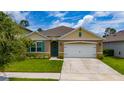 Inviting single-story home with a well-manicured lawn, charming curb appeal, and a two-car garage at 2726 Harmonia Hammock Rd, Harmony, FL 34773