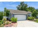 Charming single-story home featuring a well-maintained lawn, mature trees, and a two-car garage at 2926 Dickens Cir, Kissimmee, FL 34747