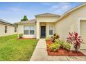 Inviting front entrance with a well-manicured lawn and colorful landscaping at 3274 Hunters Chase Loop, Kissimmee, FL 34743