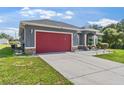 Beautiful one-story home with red garage doors and a manicured front yard at 3292 Sw 133Rd Lane Rd, Ocala, FL 34473