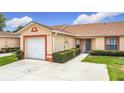 A well-maintained single-story home features an attached garage and manicured hedges at 3428 Village Green Ct, St Cloud, FL 34772