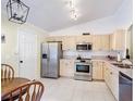 A functional kitchen features stainless steel appliances and light wood cabinets at 3428 Village Green Ct, St Cloud, FL 34772