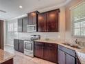 Modern kitchen features dark wood cabinets, granite countertops, and stainless steel appliances at 3603 Sanctuary Dr, St Cloud, FL 34769