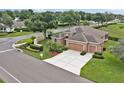 Aerial view of the landscaped single Gathering home on a corner lot with mature trees and a two-car garage at 4065 Kingsley St, Clermont, FL 34711