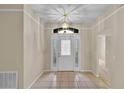 Bright foyer features neutral paint, tile floors, a decorative light fixture, and a storm door with sidelights at 4065 Kingsley St, Clermont, FL 34711