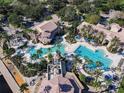 Aerial view of the community pools with palm trees, lounge chairs and umbrellas at 4109 Vessel Ct, Kissimmee, FL 34746