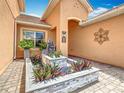 Beautiful entryway features a paver walkway and a custom water feature with colorful plants at 4109 Vessel Ct, Kissimmee, FL 34746