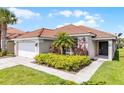 Charming home featuring a clay tile roof, well-maintained landscaping, and an attached garage at 423 Paloma Dr, Davenport, FL 33837