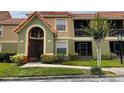 Condo exterior featuring a well-maintained lawn and vibrant shrubs at 429 Fountainhead Cir # 223, Kissimmee, FL 34741