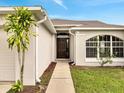 Inviting home entrance with an arched window, elegant front door, and landscaped walkway at 440 Peppermill Cir, Kissimmee, FL 34758