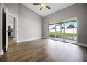 Spacious living room with wood-look flooring, sliding glass doors to the screened patio, and neutral paint at 440 Peppermill Cir, Kissimmee, FL 34758
