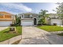 Beautifully landscaped two-story home with a spacious driveway and well-manicured lawn at 4697 Golden Beach Ct, Kissimmee, FL 34746
