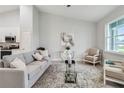 Bright living room featuring neutral walls, an accent rug, and tasteful decor, opening up to the kitchen at 515 Everest Way, Kissimmee, FL 34758
