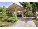 Contemporary brick home featuring a covered entryway, a well-maintained walkway and beautiful plants at 550 Lake Otis Se Dr, Winter Haven, FL 33880