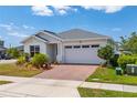 Well-maintained single Gathering home featuring a two-car garage and neatly landscaped front yard at 6651 Syreeta Ln, Harmony, FL 34773