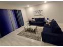 Cozy living room features plush blue sofas, a glass coffee table, and neutral decor for a relaxing atmosphere at 7773 Spectrum Dr, Reunion, FL 34747