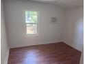 Clean bedroom with a window, hardwood floors and a wall-mounted air conditioning unit at 822 5Th St, Orlando, FL 32824