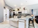 Bright kitchen featuring a central island with granite countertop, stainless steel appliances, and ample cabinet space at 824 Bloomingdale Dr, Davenport, FL 33897