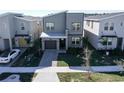 Contemporary two-story home with modern gray exterior, well-manicured lawn and landscaping in a residential neighborhood at 8974 Cabot Cliffs Dr, Davenport, FL 33896