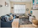 Bright bedroom furnished with a comfortable blue sofa, desk, and stylish décor illuminated by natural light at 1895 Spring Shower Cir, Kissimmee, FL 34744