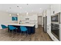 Spacious kitchen with a large island, pendant lighting, stainless steel appliances, and stylish blue bar stools at 1598 Whitewood Ct, Kissimmee, FL 34747