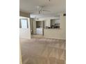 Carpeted living room with a view of a kitchen and laundry closet at 1608 Columbia Arms Cir # 126, Kissimmee, FL 34741