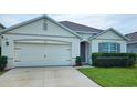 Charming single-story home with a two-car garage, manicured lawn, and neutral color palette at 2479 White Lilly Dr, Kissimmee, FL 34747