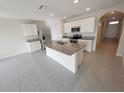 Spacious kitchen with an island, granite countertops, stainless steel appliances, and white cabinetry at 2479 White Lilly Dr, Kissimmee, FL 34747