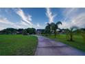 Expansive front yard featuring mature trees and long driveway leading to the home at 2851 Granada Blvd, Kissimmee, FL 34746