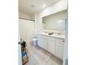 Bright bathroom with double sinks, white cabinetry, neutral tile, and shower/tub combo at 2915 Turnstone, St Cloud, FL 34773