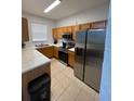 Well-lit kitchen equipped with stainless steel appliances, ample wood cabinetry and stone countertops at 324 Palermo St, Davenport, FL 33897