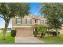 Spacious two-story home with a two car garage, colorful shutters and mature trees in a manicured lawn at 3335 Whistling Trl, St Cloud, FL 34772