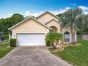 Charming one story home featuring a two-car garage, manicured landscaping, and a large driveway at 341 Whittier St, Davenport, FL 33896