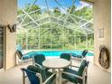 Screened in pool and lanai area with ample seating and dining with views of natural lush trees at 341 Whittier St, Davenport, FL 33896