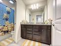 Well-lit bathroom featuring granite countertops, dual sinks, and glass-enclosed shower at 3878 Lana Ave, Davenport, FL 33897