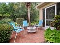 Cozy outdoor patio area with brick pavers, comfortable seating, and lush greenery at 516 Millifiora Ln, Kissimmee, FL 34759